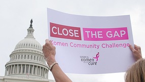 A breast cancer survivor waves a poster during the Komen Community Challenge rally 26 April, 2007 on Capitol Hill in Washington, DC. The Susan G. Komen for the Cure released the 'Breast Cancer Mortality Report: Closing the Gaps in Eight Communities,' which gives an in depth look into eight communities with unusually high breast cancer mortality rates. AFP PHOTO/Karen BLEIER (Photo credit should read KAREN BLEIER/AFP/Getty Images)