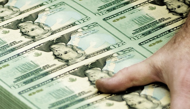  A pressman inspects the roll out of $20 bills